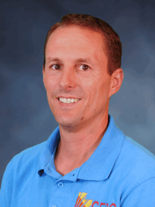 Trujillo Amy, Clinical Mental Health Counselor, is a smiling man with short brown hair. He is wearing a light blue polo shirt with the red and yellow SEDC logo on the right side of his chest.